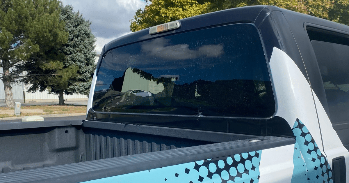 The cracked rear window of a pickup truck in need of back glass repair.