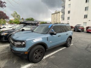 A light blue Ford Bronco Sport parked in a lot, showcasing the need for professional auto glass repair.